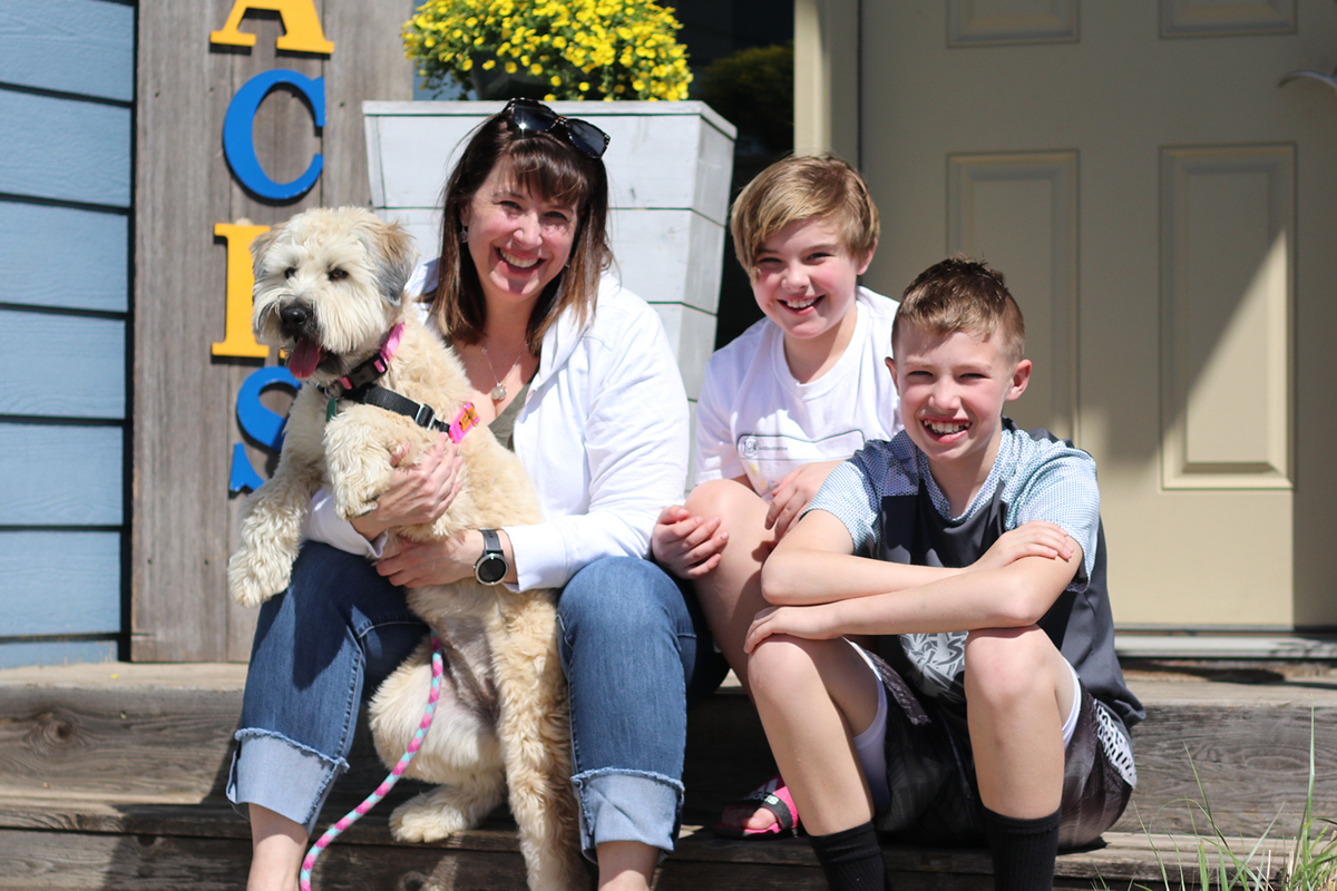 Amy Smolik with her children and dog on their front porch