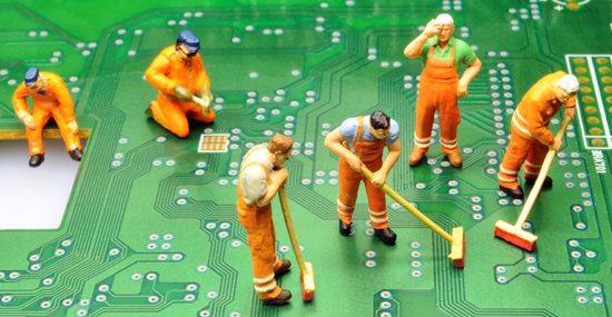 Little figurines cleaning a computer circuit board