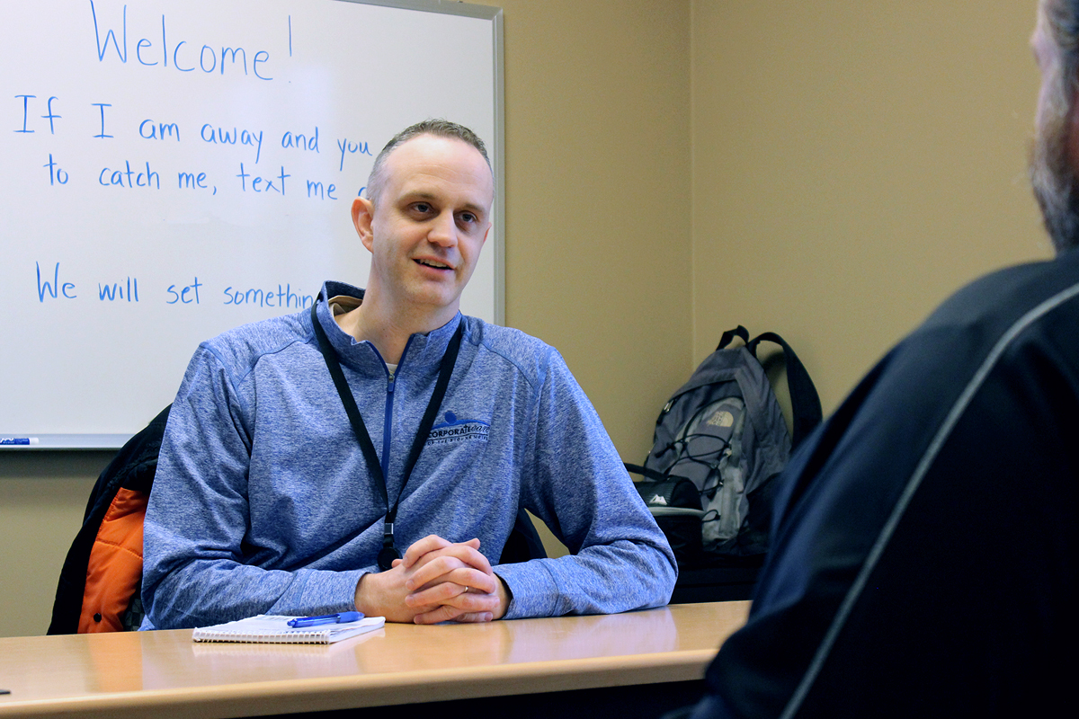 John Warden talking with employee at a desk