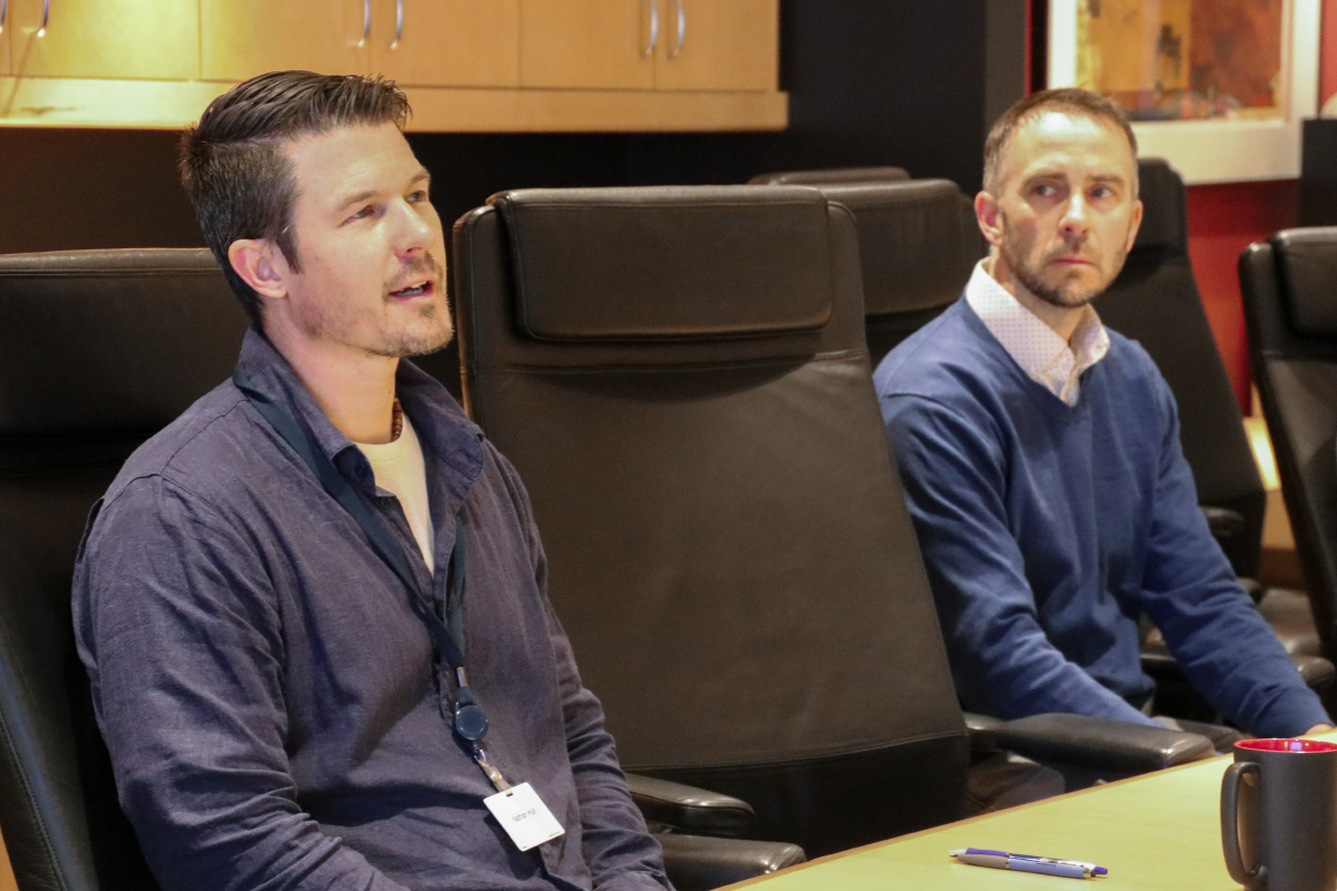 Two employees in discussions at board room table