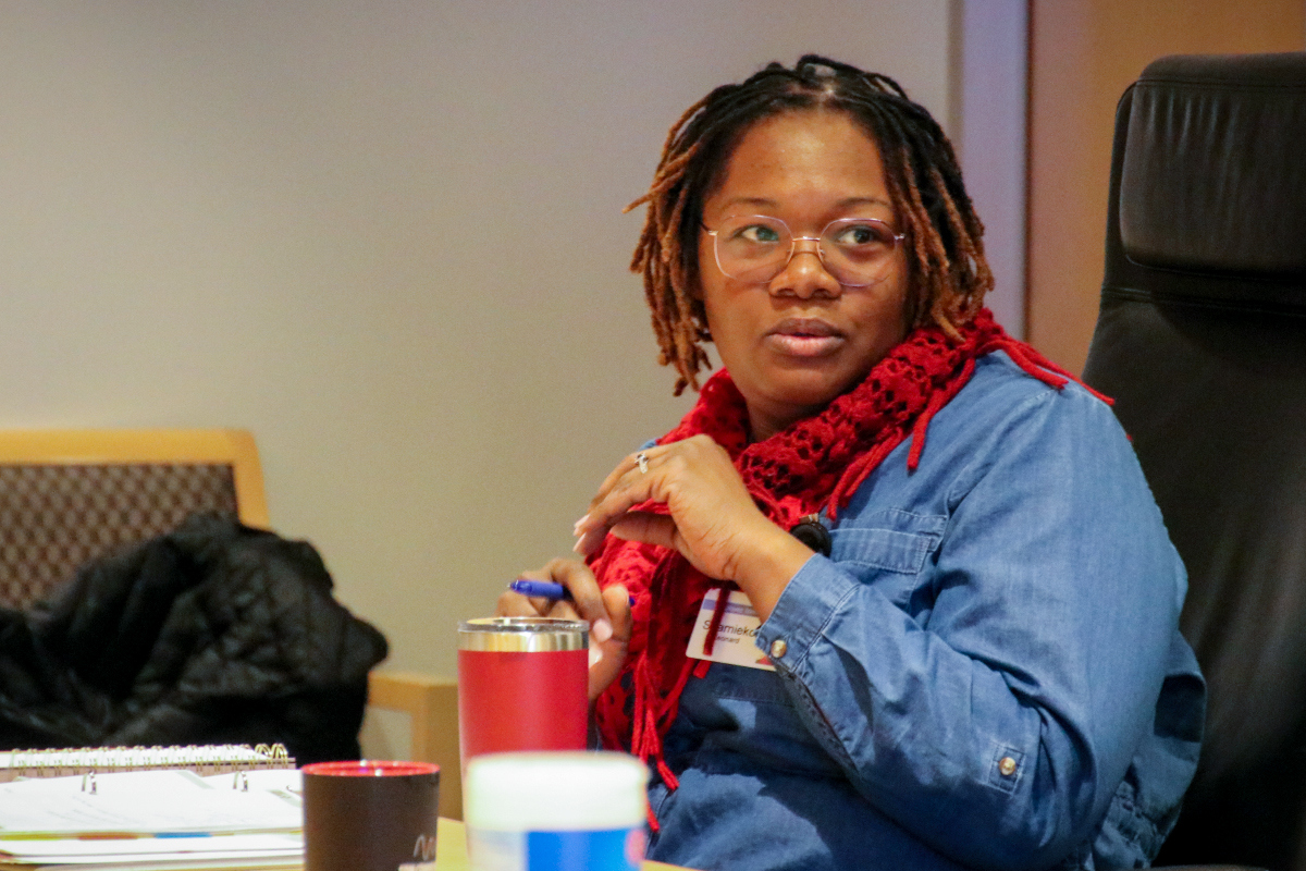 Shameko talking at the board room table