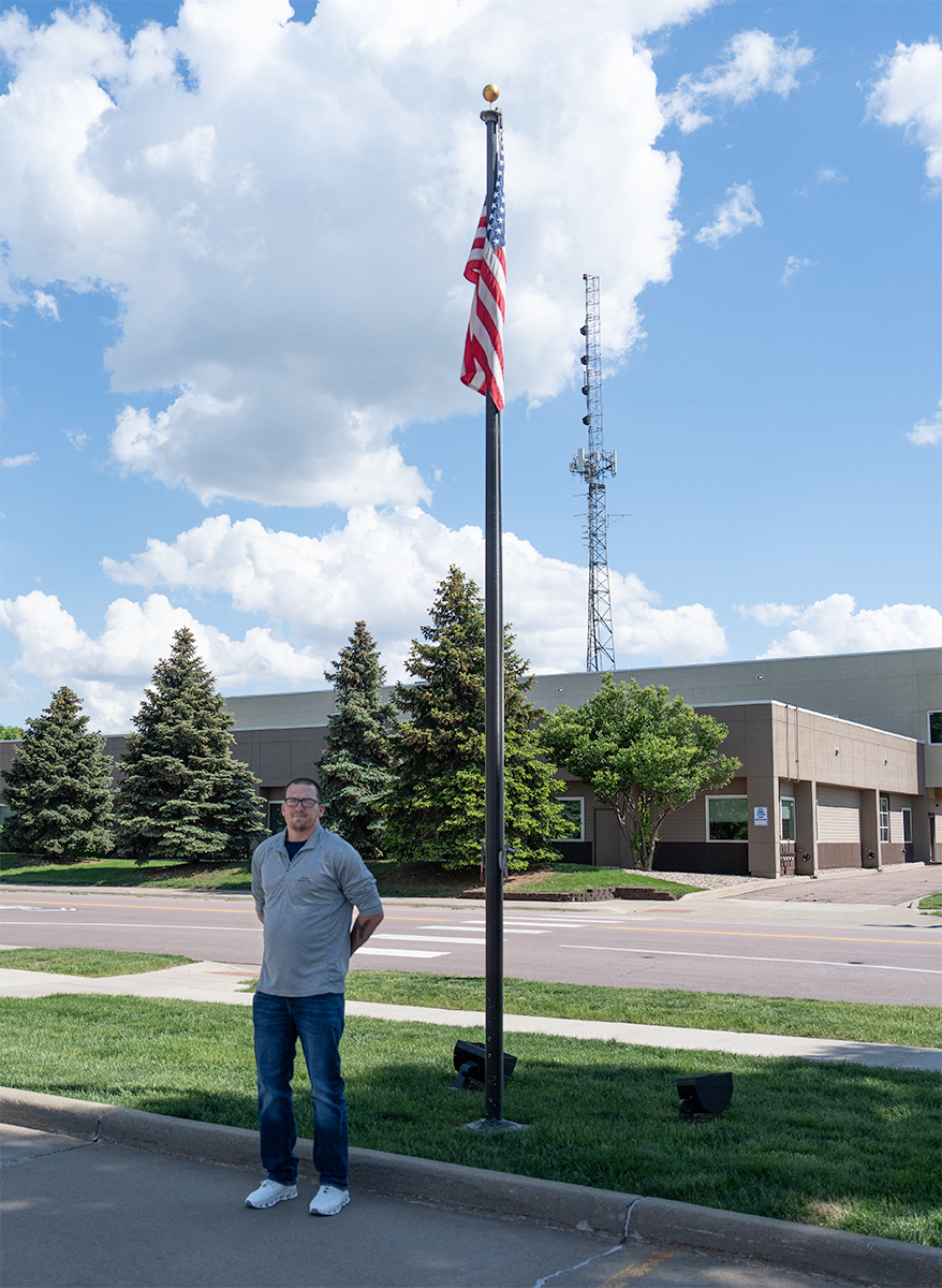 Eddie Cotton stands near the American Flag as he previously served in the United States Marine Corps