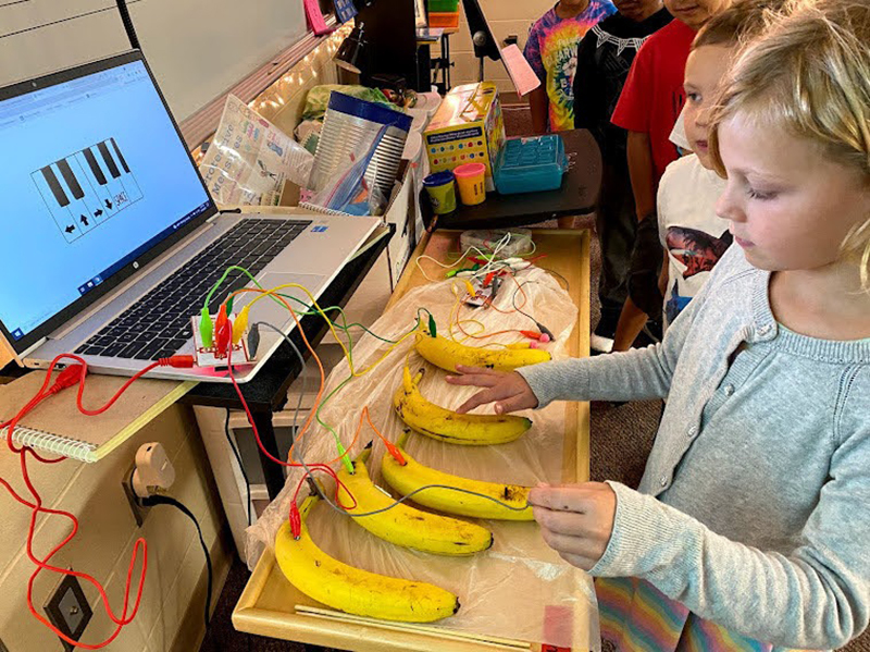 A student uses Makey Makeys to turn bananas into a piano thanks to donations from the Education Foundation.
