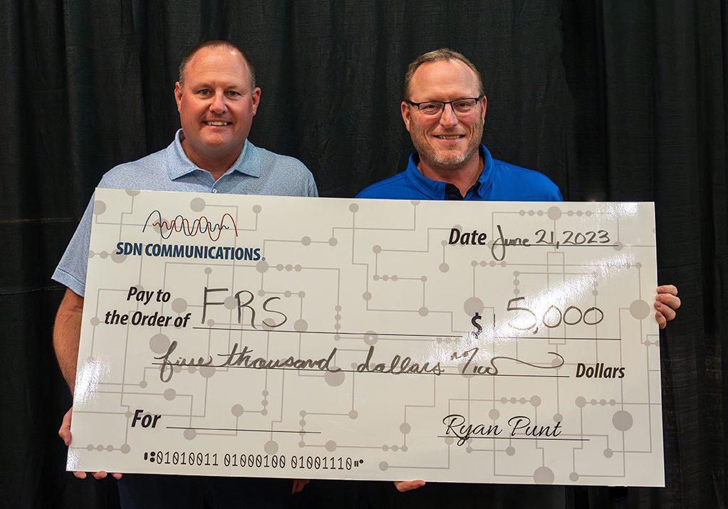 SDN Communications CEO Ryan Punt presents Foundation for Rural Service board member Chad Mutziger with check