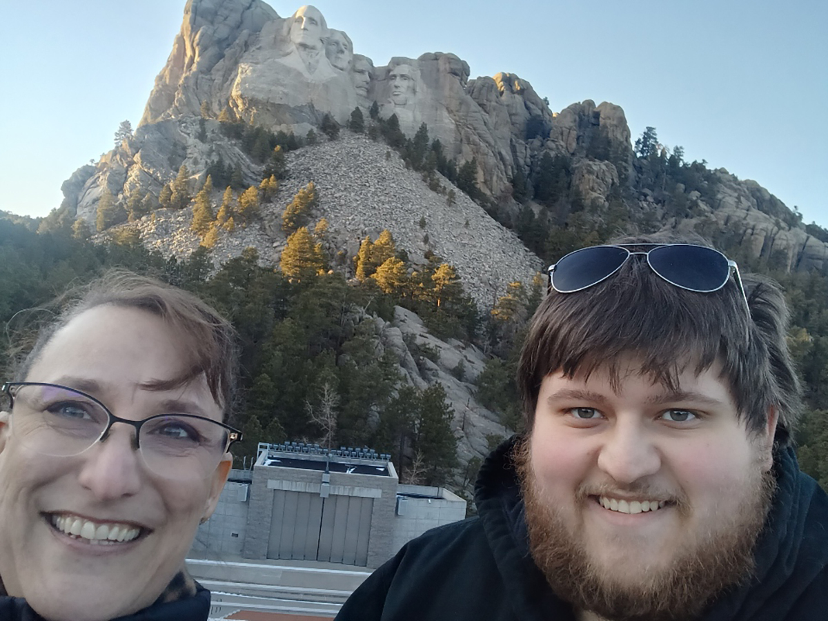 A mother and her son take a selfie in front of Mount Rushmore