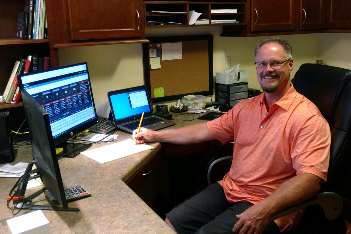 Greg Robinson at his computer in his home office