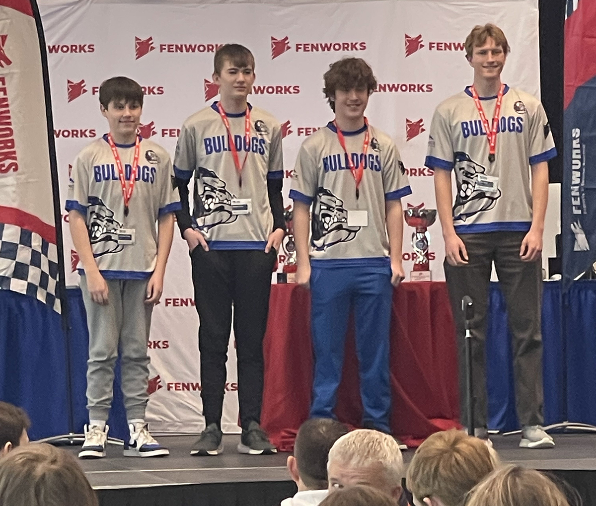 Four high school esports athletes from Baltic, South Dakota, stand on the stage after receiving an award