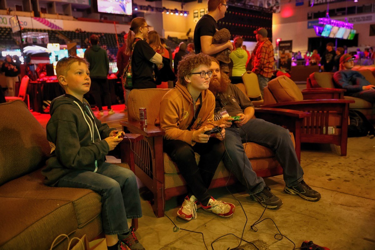 Kids play the Nintendo Switch while sitting on a couch in an arena.