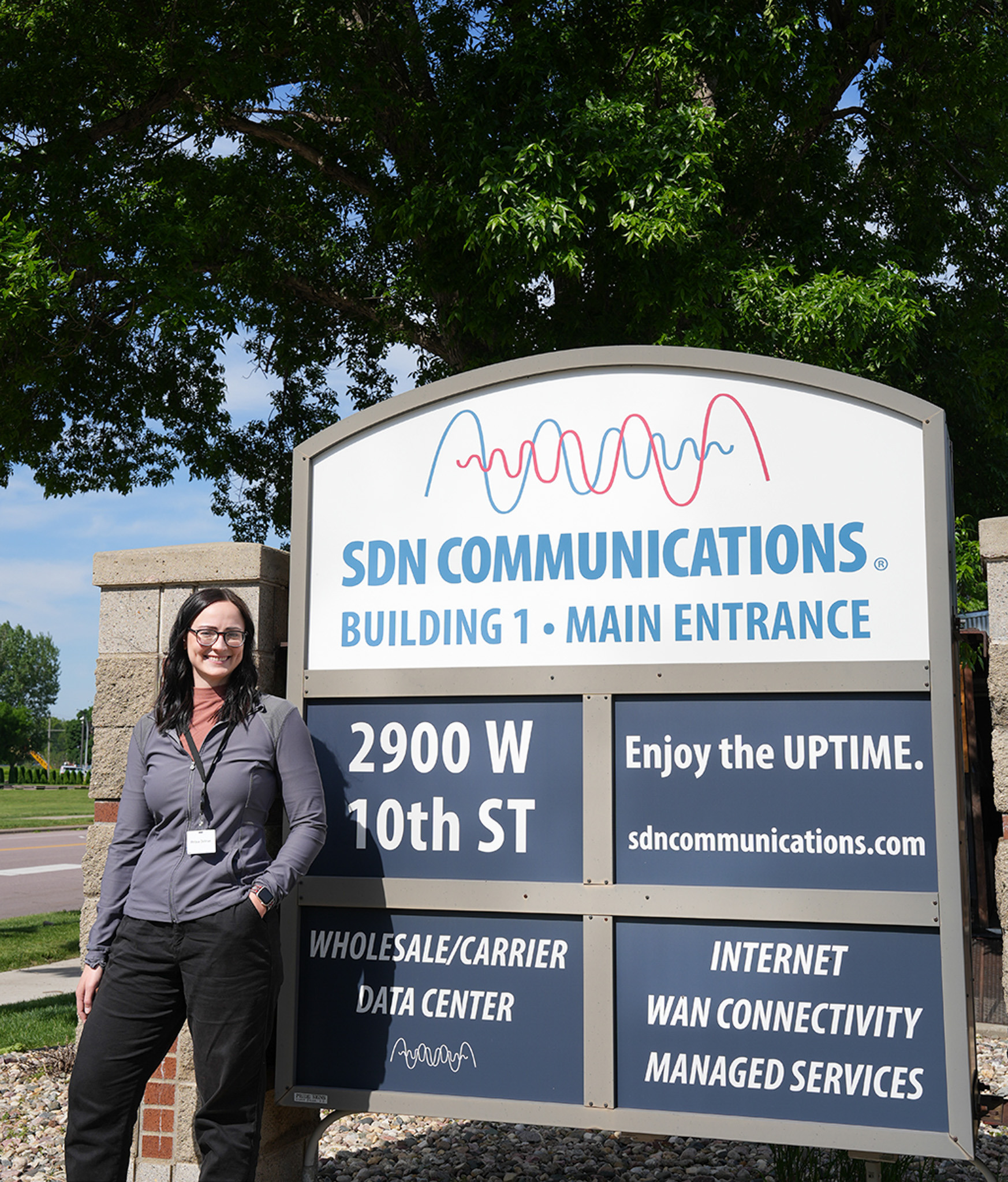 Melissa Dellman stands near front signage of SDN Communications.