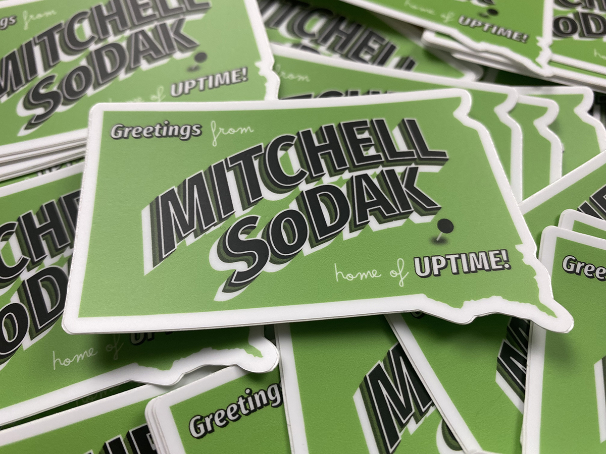 A pile of green stickers with "Mitchell South Dakota" written on it.