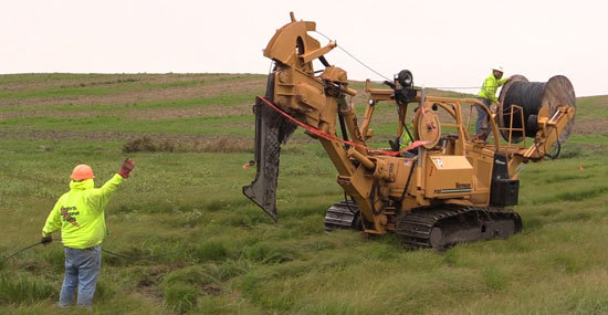 Crews pull fiber optic lines and plow into the ground in rural areas