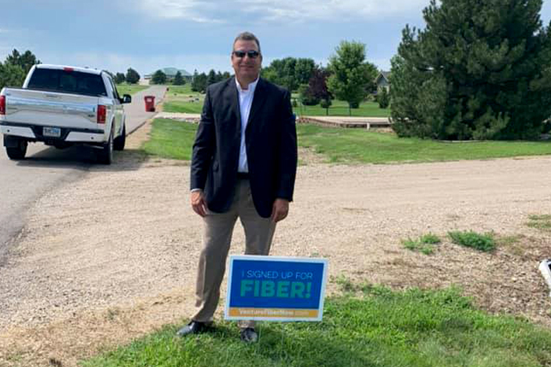 Randy Houdek with sign: I signed up for fiber