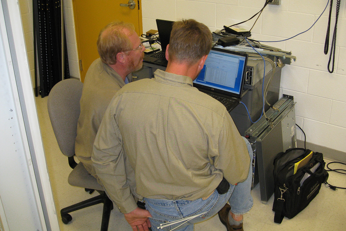 Russ Lampy (left) is shown working on the state of South Dakota's network with a State of South Dakota employee.