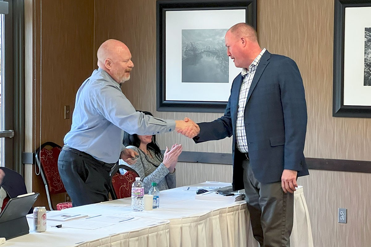SDN Communications sales engineer Russ Lampy shakes hands with CEO Ryan Punt