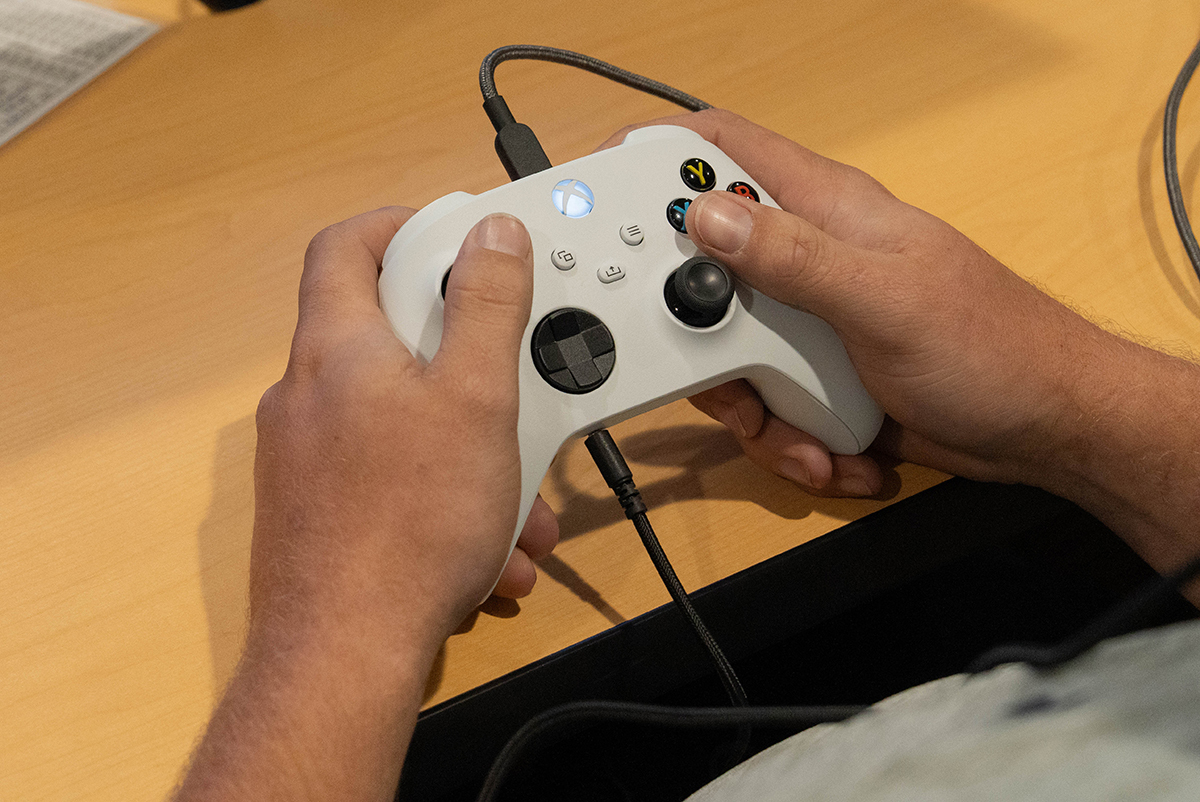 Close-up of two hands gripped around an XBox controller.