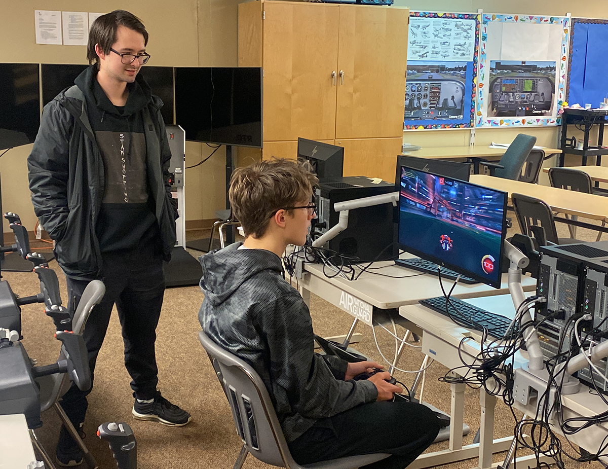 Sioux Falls esports coach Coach Johnathan Halleen watches as Jacob Markley competes in a Rocket League game at CTE Academy in Sioux Falls.