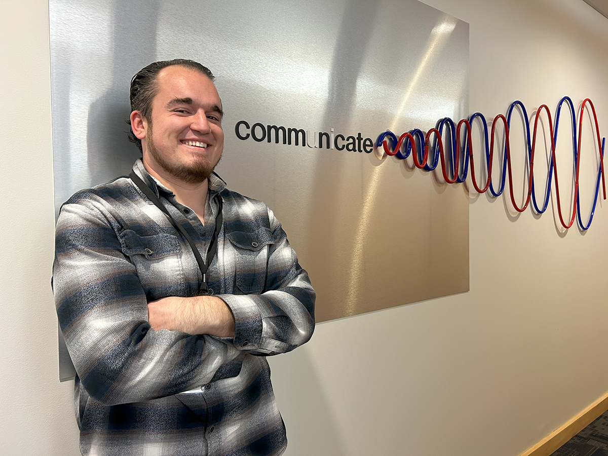 Will Brown stands next to an SDN Communications sign at their headquarters in Sioux Falls