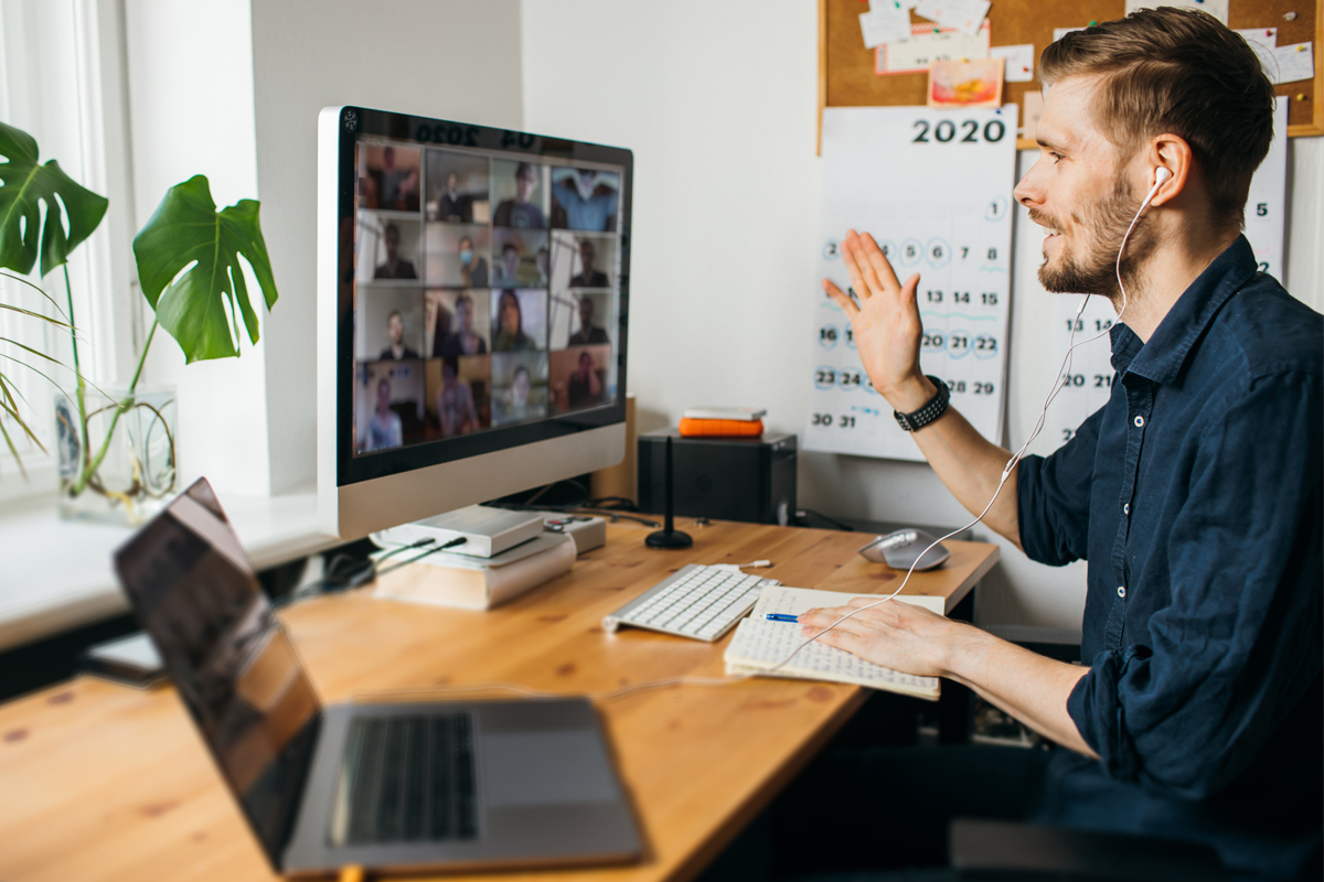 male employee working from home at a desk and taking a video call