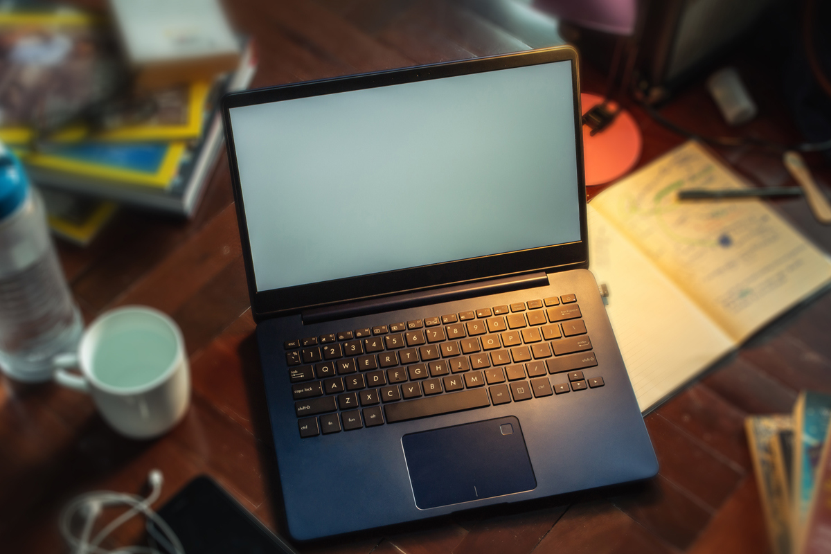 Closeup of laptop computer on table with home items