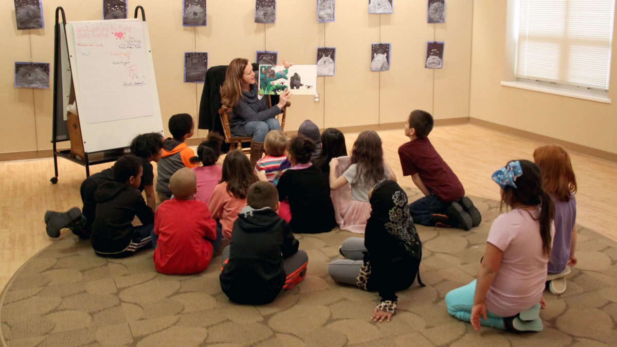 SDN employee reading to group of students