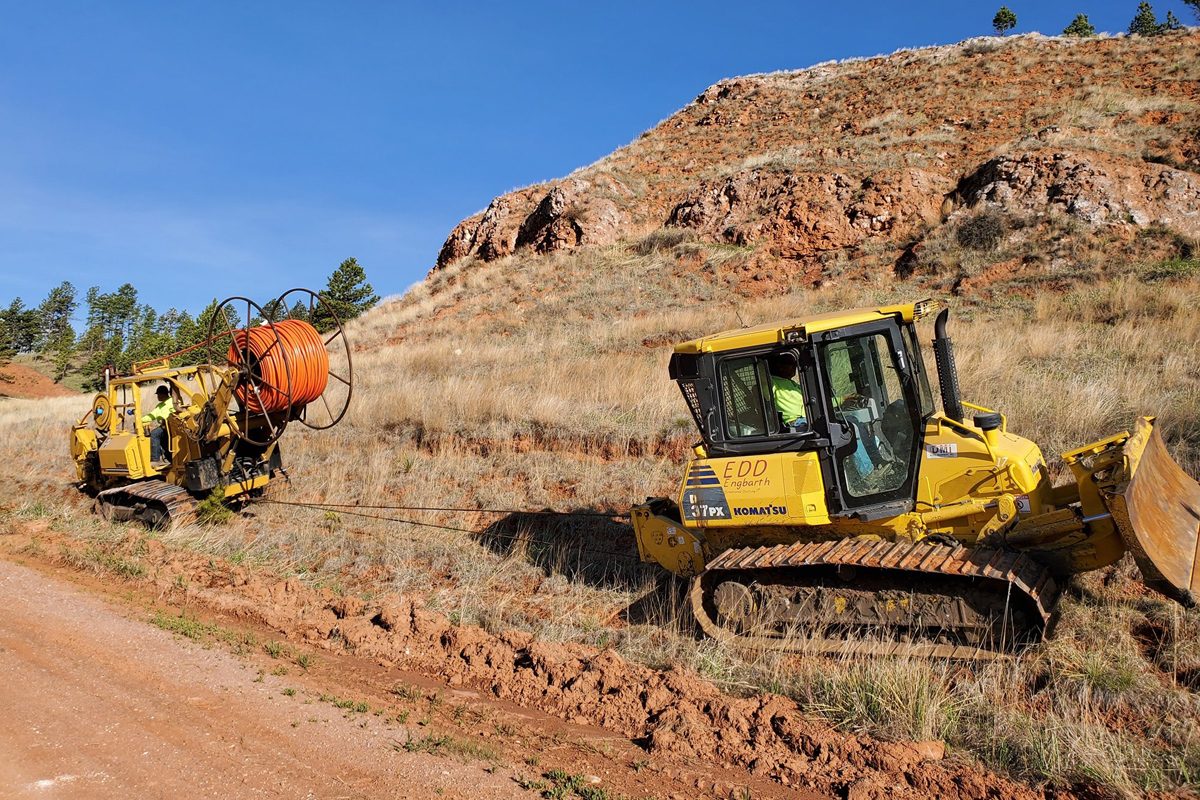 Large equipment installing fiber into the red rock of Rapid City