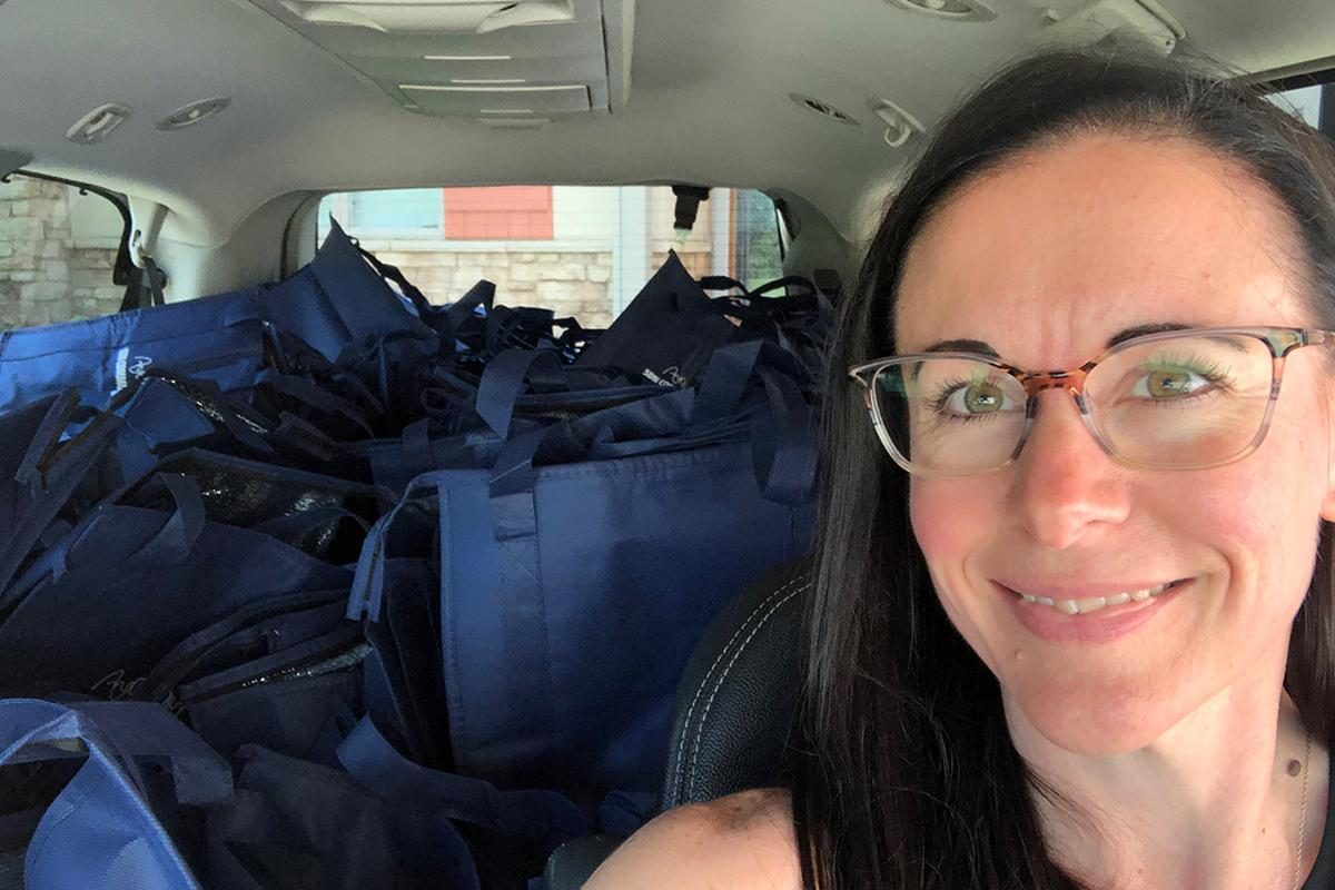Amanda Bormann's selfie with a van full of blue gift bags