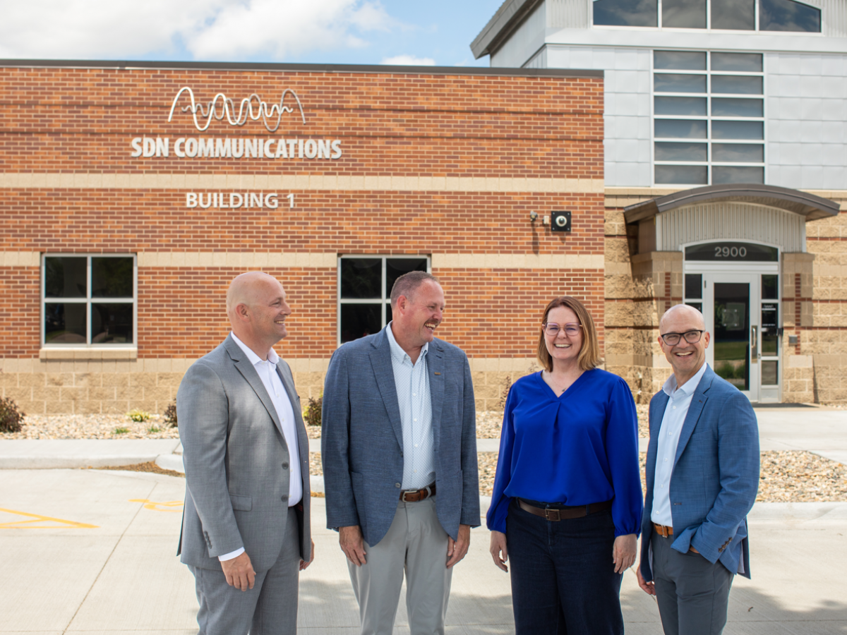 The SDN Communications executive team of Ryan Dutton, Ryan Punt, Sarah Tuntland and Jake VanDewater pose for a photo outside of the SDN building