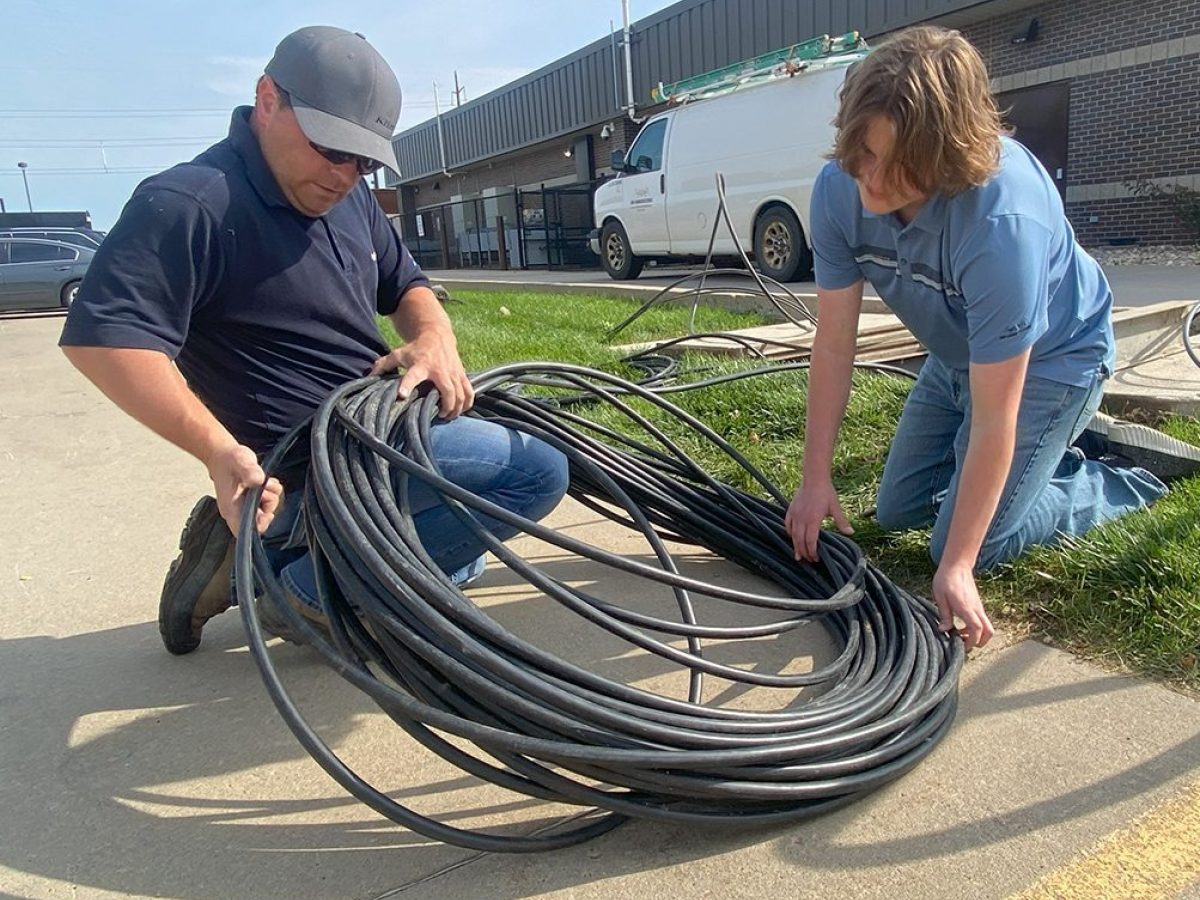 SDN Employee working in a fiber box for business internet along a sidewalk