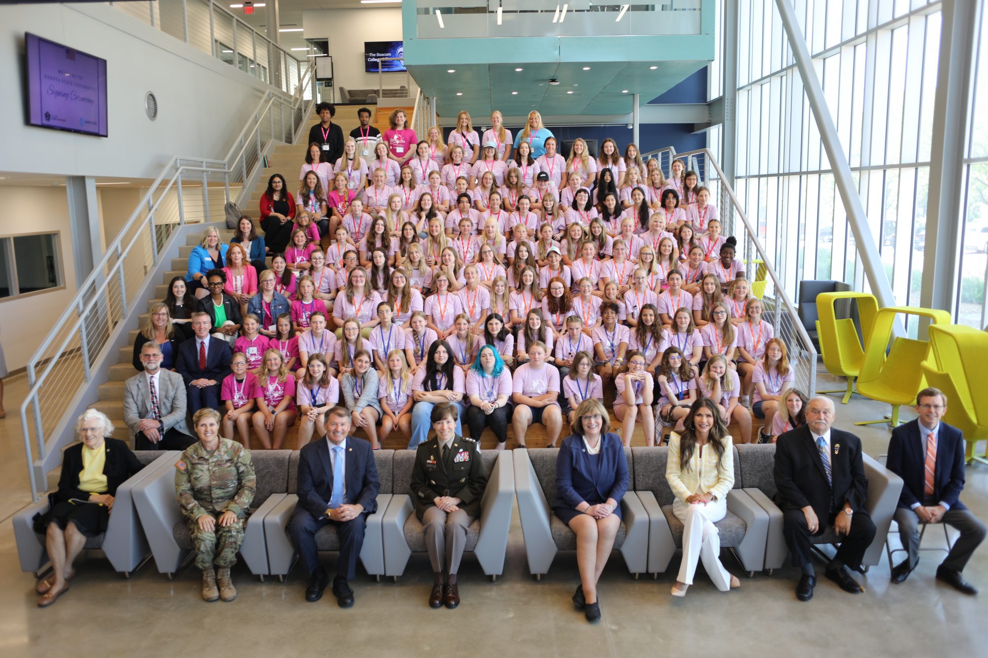The 2023 Dakota State University CybHER camp participants pose for a group photo with Gov. Kristi Noem and other guests.