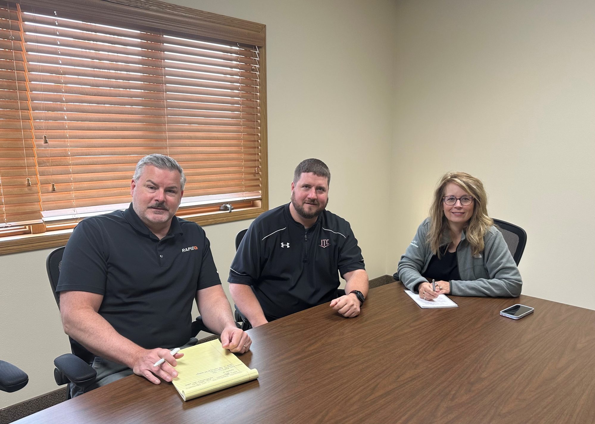 Executive team of Interstate Telecommunications Coop sits at a table.