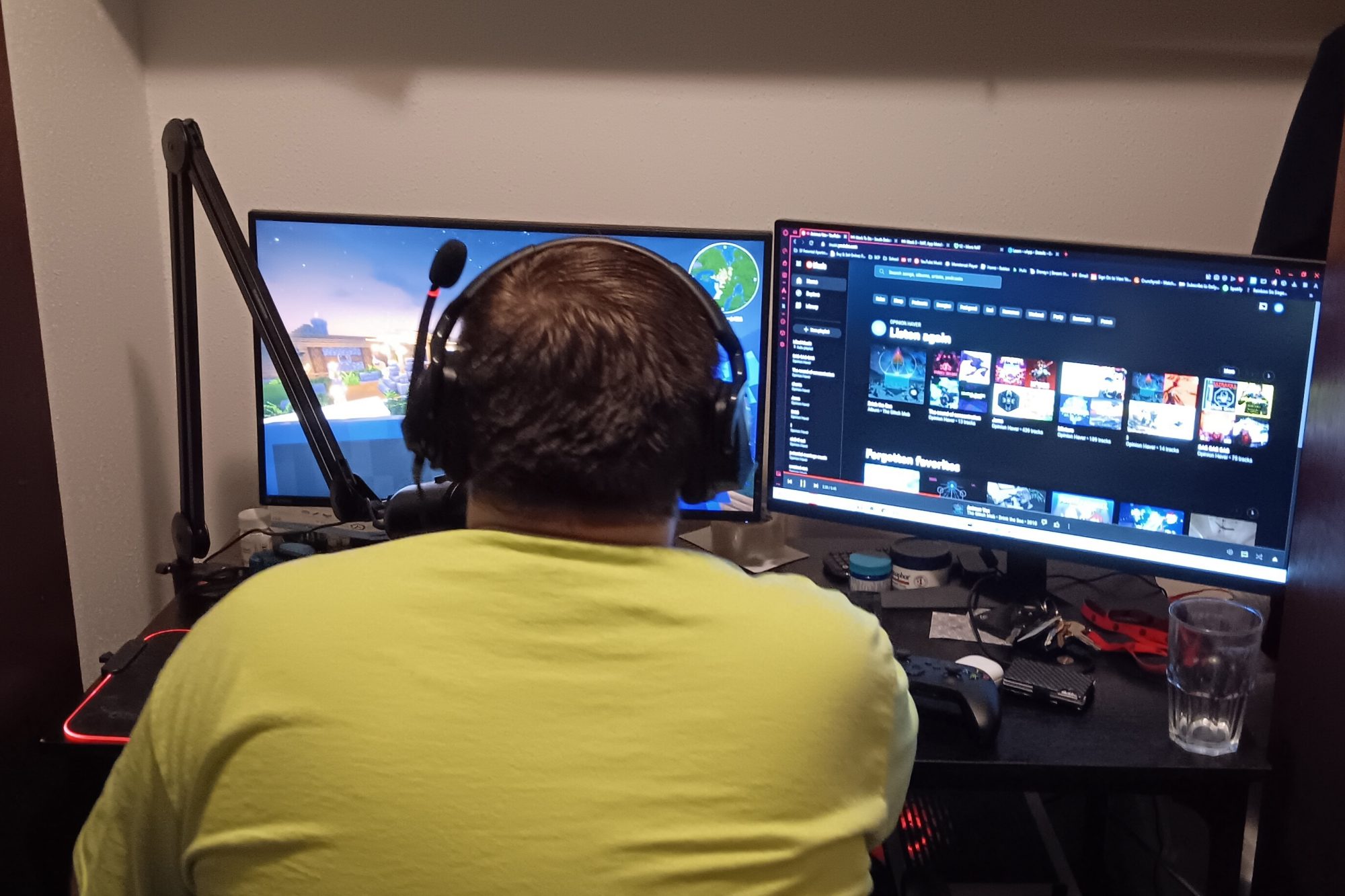 A man plays video games with two computer monitors