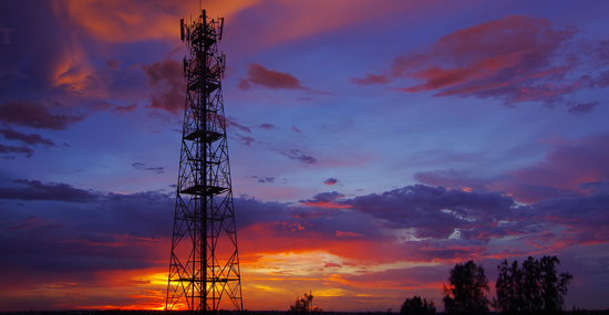 A cell phone tower is shown at dusk.