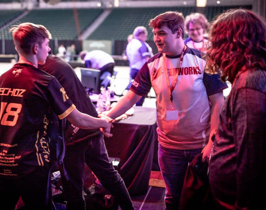 Esports players shake hands after a match.