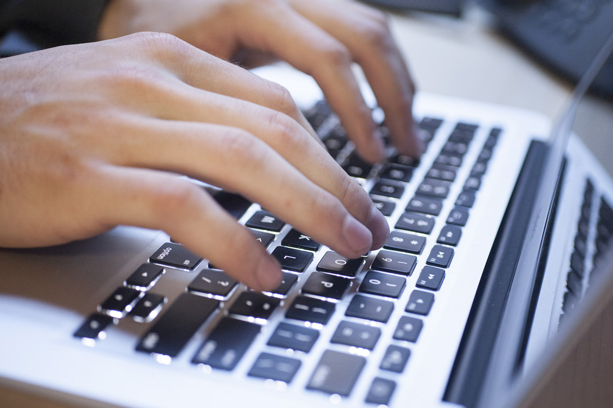 keyboard fingers typing on laptop