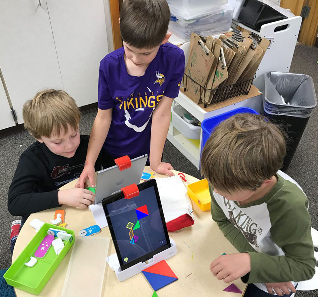Students work on creating shapes with the help of an iPad